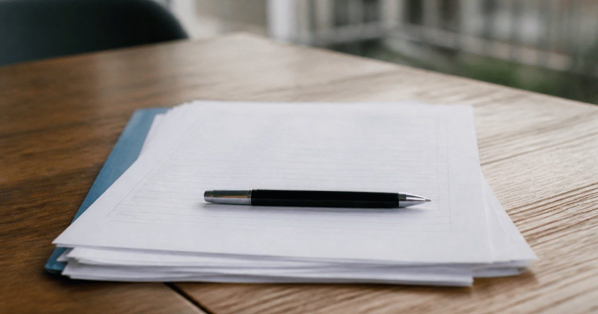 Contrat immobilier signé avec stylo posé dessus horizontalement
