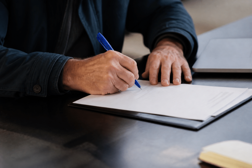 Contrat signé avec stylo bleu sur bureau professionnel