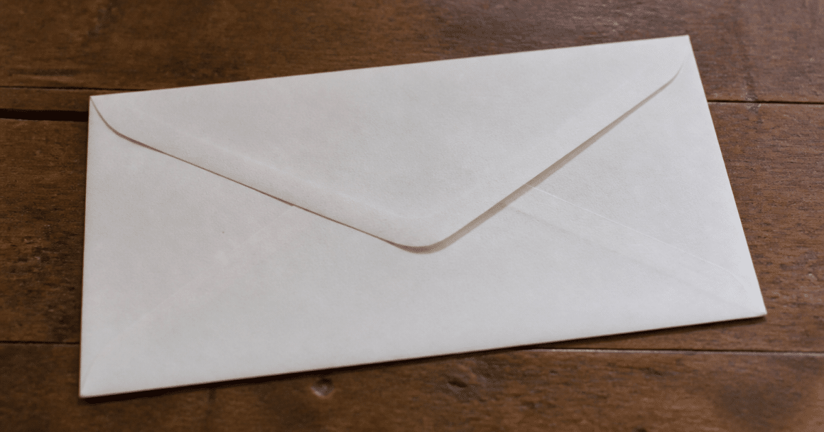 Enveloppe postal affichant code cinq chiffres francais sur surface blanche