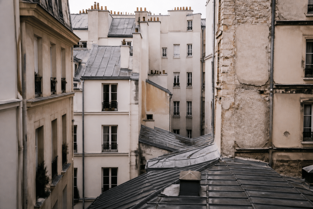 Maisons mitoyennes et immeubles serrés dans quartier urbain dense.