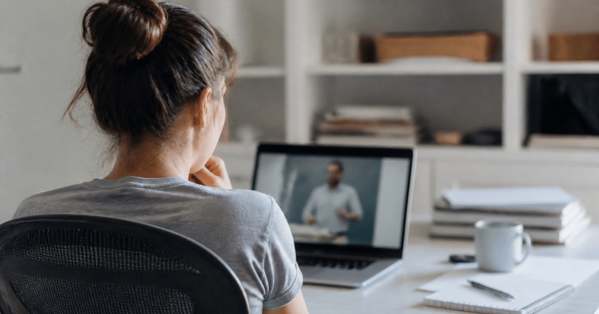 Personne assise à bureau suivant formation en ligne sur écran