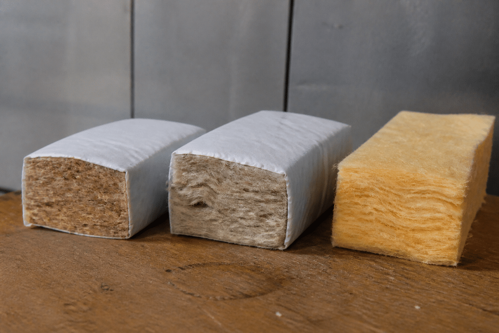 Trois echantillons isolants montrant revetement kraft blanc et fibre nue