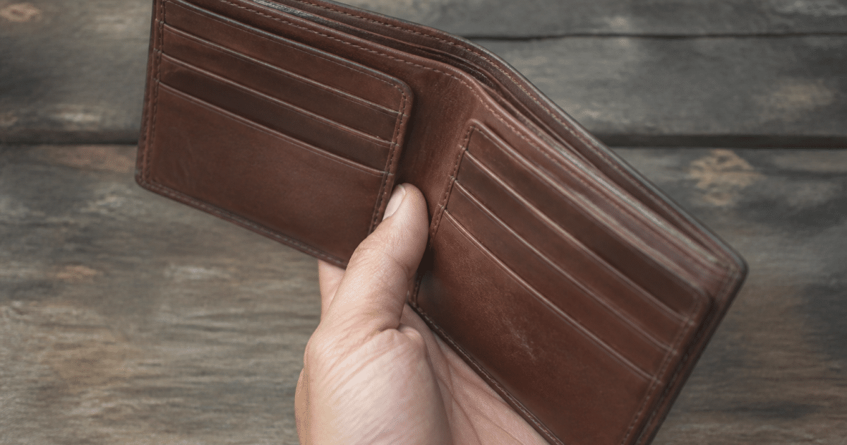 Portefeuille marron en cuir pose ouvert montrant compartiments cartes