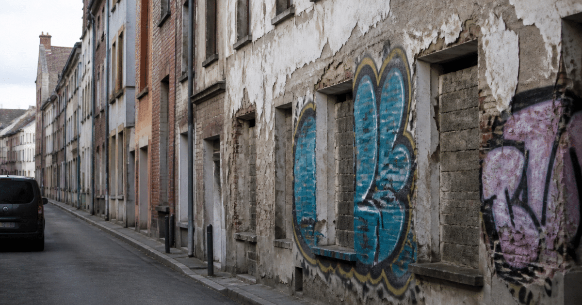 Rue urbaine avec immeubles deteriores et facades graffitees
