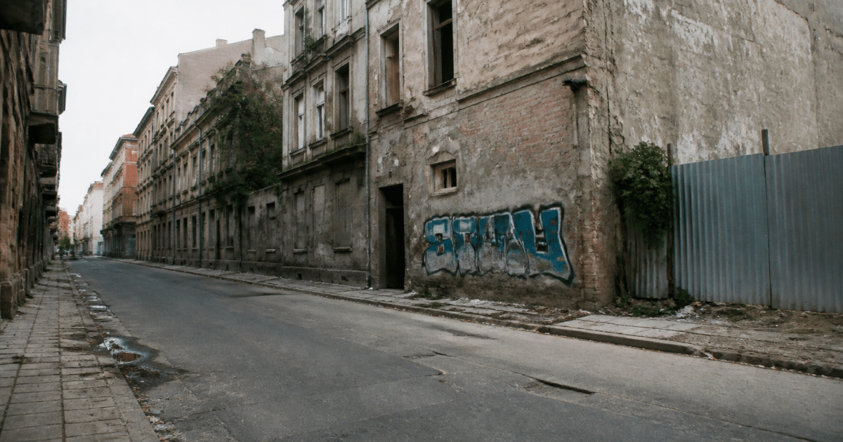 Rues desertes avec immeubles deteriores et graffitis visibles