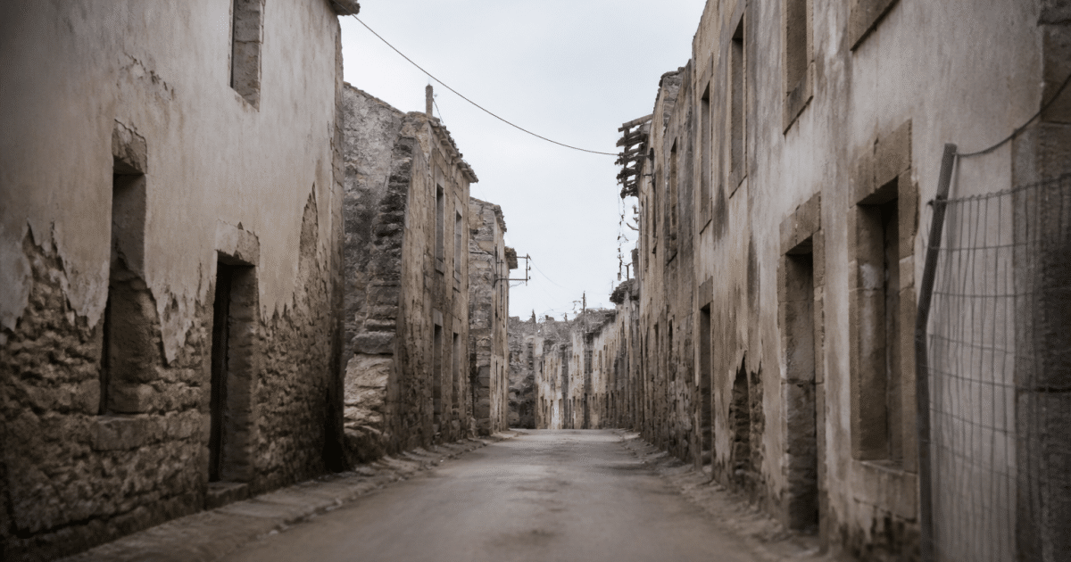 Rue vide avec batiments deteriores et panneaux d'avertissement visibles
