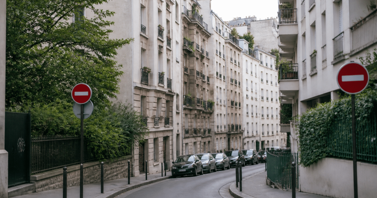 Rue urbaine avec immeubles residentiel et panneaux routiers visibles