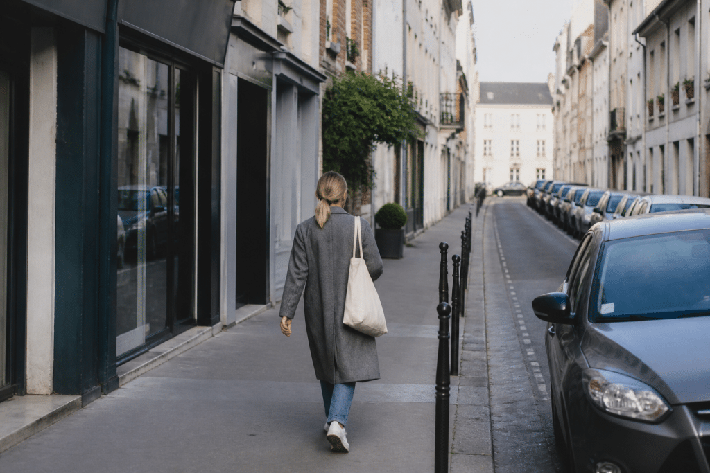 Personne marchant dans rue Houilles avec commerces et maisons visibles